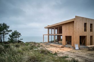 Maison en bois en construction face à l'océan Atlantique à Saint-Nazaire, charpente en douglas et vue mer